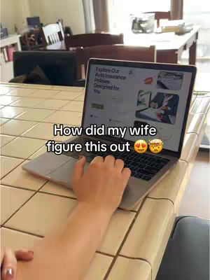A person is working on a laptop on a tiled surface, other elements in the background include a table, chairs, and part of a window. The laptop screen displays a website interface. Text overlayed at the bottom reads: "How did my wife figure this out" followed by two emojis.