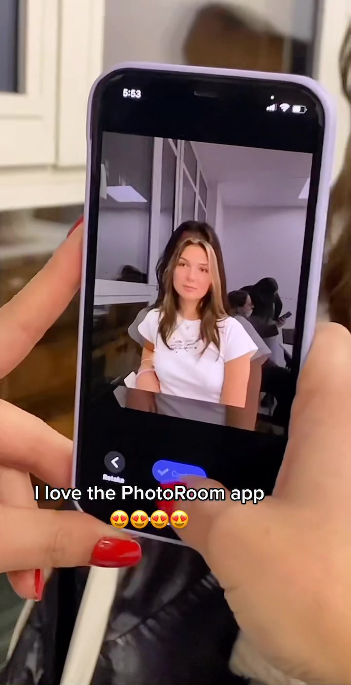 Cover image showing a smartphone displaying a woman’s photo altered by the PhotoRoom App. The smartphone is held by hands with painted red nails. The bottom of the screen has the text 'I love the PhotoRoom app' written on a white background, with four heart emojis. In the smartphone screen, the woman has brown hair, is wearing a white shirt, and is positioned in a neutral studio background.