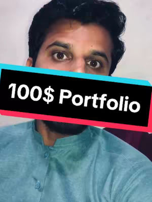 A man's face dominates the frame, partially obscured by a black rectangular overlay. The overlay features the text '100$ Portfolio' in white. The man has dark hair, and is wearing a blue shirt, and looking directly at the camera. The background is plain, with neutral lighting. The composition is simple and direct, focusing primarily on the man’s expression and the text.