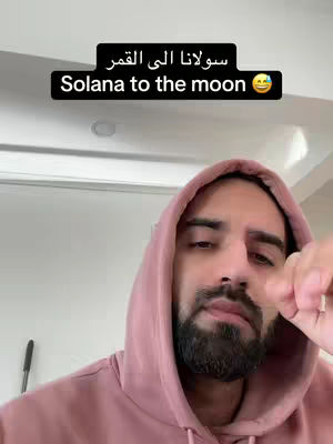 A close-up shot of a man wearing a pink hoodie, with the text overlay "Solana to the moon".  He has a beard, and is looking towards the camera.