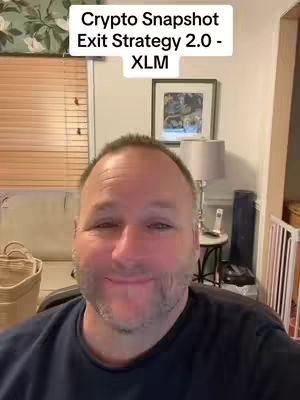 The cover image features a man in a selfie-style shot. He is centered in the frame with a slightly smiling expression. The background includes elements of his living space: a window with blinds, a couch, and a glimpse of a framed picture. The lighting appears to be natural. On the top-left side, there's a text overlay that reads 'Crypto Snapshot Exit Strategy 2.0 - XLM'.
