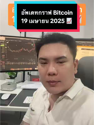 A man in a white polo shirt is seated in an office setting. Behind him are two computer monitors displaying stock charts. Overlayed on the image at the top is a colored banner with the text in Thai language. The man is looking at the camera.