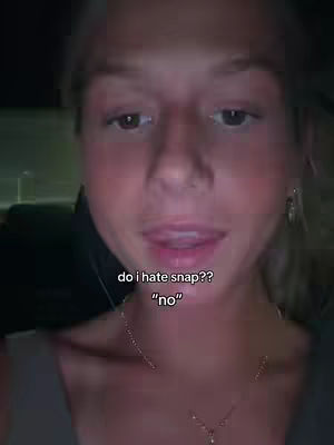 A close-up shot of a woman's face. She is looking at the camera with her mouth slightly open and her tongue touching her lower lip. Overlayed text asks, "do i hate snap??" followed by the word "no" below it. The background is dark and blurred.