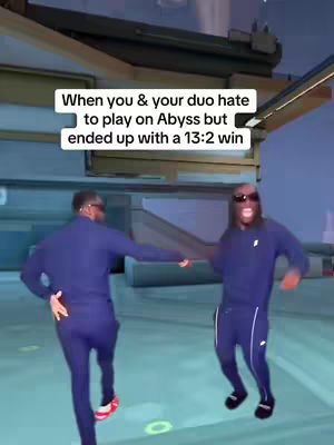 Two men in matching blue tracksuits and sunglasses are dancing and celebrating in a video game environment. A text overlay conveys the sentiment of hating something but still achieving a win. The scene blends real-world action with a digital gaming backdrop.