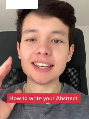 A young man with dark hair is centered in the shot, looking directly at the viewer with a slight smile. He's wearing a gray shirt and is seated. Below him, a red banner reads "How to write your Abstract". The background is blurred.