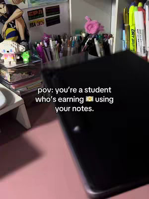 The cover image shows a desk set up with books, stationery, and the corner of a pink desk. A black notebook is in the foreground with added text overlayed. In the background there's various stationery and decoration.