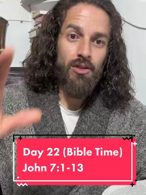 A man with long, wavy dark hair and a beard, wearing a gray robe, is looking at the camera and gesturing with his hand. A red banner on the bottom displays text detailing the video's theme.