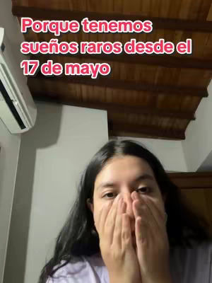 A young woman covers her mouth with both hands, looking towards the camera with a slightly apprehensive expression. Above her, a text overlay in pink reads, "Porque tenemos sueños raros desde el 17 de mayo" against the background of an indoor setting with a wooden ceiling visible.