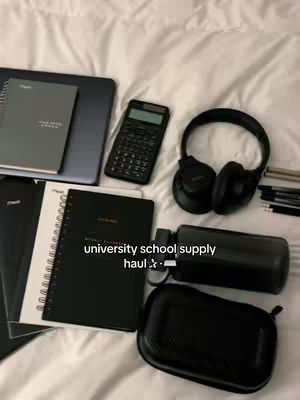 The cover image shows an array of university school supplies. These supplies including a laptop, spiral notebooks, a calculator, headphones, a water bottle, and a pencil case, all arranged on a white bed sheet. The layout is a top-down view, giving a clear presentation of the items.