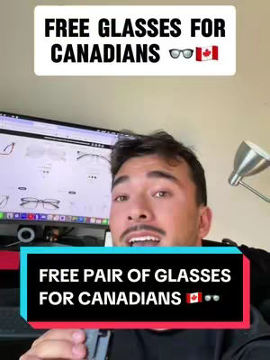 A man with short dark hair and a light complexion is looking directly at the camera. He is in front of a computer monitor displaying a website with images of eyeglasses. Text overlays appear at the top and bottom of the frame, advertising free glasses for Canadians.
