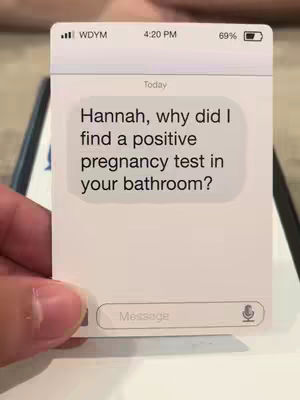The cover shows a hand holding a phone-shaped card. The card is white with a simulated phone interface, showing a text message on a light background. The text bubble reads: Hannah, why did I find a positive pregnancy test in your bathroom? At the top are virtual phone indicators, like the mobile carrier, battery level, and time. The bottom of the screen contains a text input field labeled "Message" and a microphone icon.