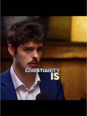 The cover image features a young man with short, dark hair and a subtle mustache. He's wearing a white collared shirt under a dark blue blazer. The background is blurred, with warm tones suggesting an indoor setting. Overlayed text reads 'Christianity Is' in a stylized font.