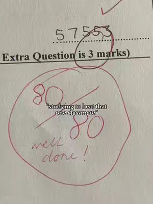 A close-up of a test paper with a circled score of "80" and the words "well done!" written below it. The paper is labeled with numbers and a statement about an "Extra Question."