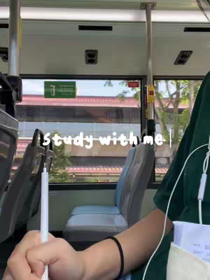 A person is on a bus holding a pen, preparing to study. The bus windows show the outside setting, with the text "study with me" overlaid on the image.