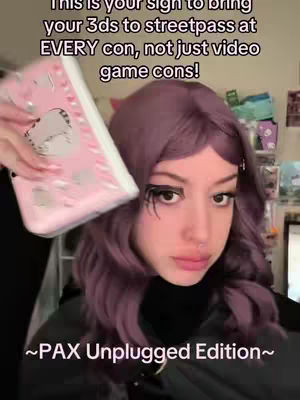 A selfie-style image featuring a person with purple hair holding a pink Nintendo 3DS XL. Text overlays promote the use of the device at gaming conventions. The background is slightly blurred.