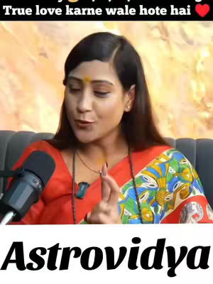 The cover of the video features a woman in the foreground, speaking into a microphone. She is wearing a red top and a shawl with a colorful print. Her face is visible, and she has a bindi on her forehead. Behind her is a blurred background.