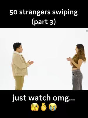 The cover image features two people standing opposite each other against a white background, engaged in a potential speed dating scenario. Above the image is the text "50 strangers swiping (part 3)" in white, with a black background filling the rest of the top portion. At the bottom the words "just watch omg..." are followed by three emoji. The man and woman are spaced apart, with hands raised, presumably gesturing. The man is wearing a beige jacket, khaki pants, while the woman has a casual t-shirt and jeans.
