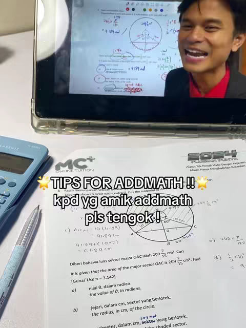A man is smiling into the camera, with a tablet screen behind him displaying math equations and a worksheet with additional mathematical diagrams and formulas. The foreground features a calculator, pen, and what appears to be a printed exam paper.
