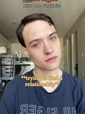 A young man with fair skin and short, dark hair looks slightly off-center towards the right. The background shows a room with beige walls and neutral tones.