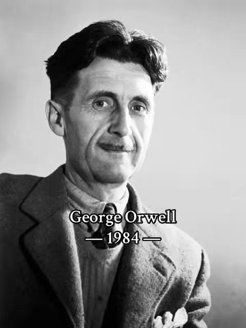 A grayscale photo of a man, George Orwell, with text overlayed. The man has short, dark hair and is looking into the camera. He is wearing a suit jacket, a collared shirt, and a tie. The text overlay says "George Orwell - 1984".