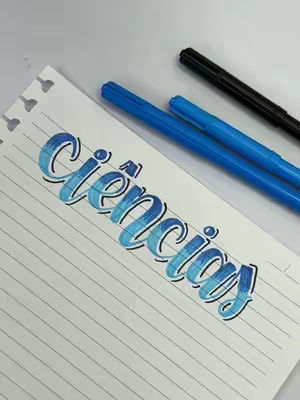 A close-up shot of a white sheet of lined paper with the word "Ciências" (Sciences in Portuguese) written on it in a vibrant, gradient blue lettering with a black outline. Three pens, two blue and one black, are placed on the paper. The composition is simple, focusing on the lettering and supplies.
