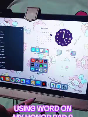 A screenshot showing the screen of an Honor Pad 9 tablet. On the tablet's screen is a custom background with a My Melody theme, including drawings and a calendar. Several app icons are arranged across the bottom, and a black sidebar is open on the left. A pink stylus pen is partially visible, pointing towards the screen that displays various application icons.