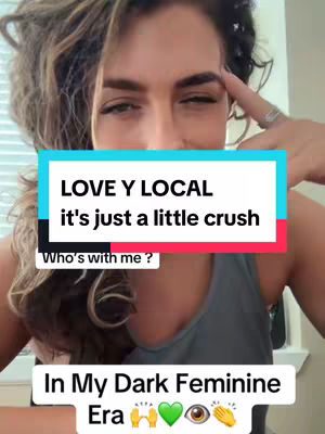 A selfie-style video cover image featuring a woman with wavy hair, looking towards the camera with a slight smile. She is wearing a casual top and has a light background. Overlay text is present in the image, with the phrases "LOVE Y LOCAL" and "it's just a little crush. The image has filters that give it a vibrant and modern look.