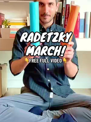 A man sits in front of a shelf of books, holding two cylindrical cardboard tubes. The tubes are blue and orange. Text overlays the image, highlighting the video's focus on the Radetzky March.