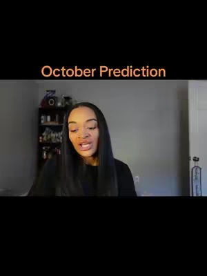 The cover image features a woman with long dark hair, facing the camera and speaking. Above her is orange text that reads "October Prediction." The background is a gray wall, and a cabinet with various items is visible.