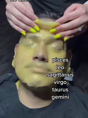 A close-up shot of a man's face covered in a yellow face mask. Hands with bright yellow manicured nails hold the mask during removal. Text overlays list zodiac signs.