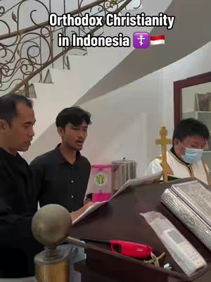 The cover image shows a group of men in a domestic setting, seemingly in a church or a similar religious space. Three men are in focus; one is holding a book, the others are looking at the camera, apparently singing or speaking. The setting has wooden furnishings and a cross is visible; the image implies a religious performance or service.