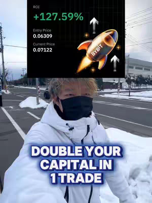 A selfie-style video cover with the creator in the foreground, wearing a black face mask and a white coat. In the background, a screen displays financial information including ROI and other data, and a rocket graphic with the BYBIT logo. Below this screen, the overlaid text reads "DOUBLE YOUR CAPITAL IN 1 TRADE" with a blue and white gradient effect. The overall composition features a snowy outdoor scene.