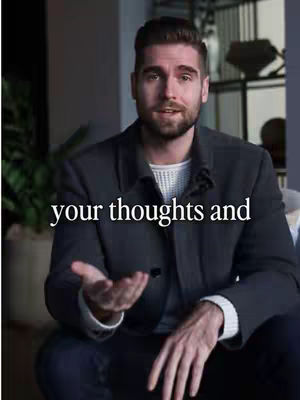 A man in a blazer is sitting and speaking with his hand up. Below him is the text overlay.