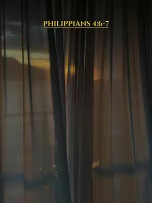 The image showcases a blurred view through curtains or drapes. The lighting suggests a sunrise or sunset, with a warm, golden glow visible. The focus is soft, with vertical lines providing structure.