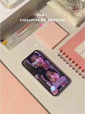 An overhead shot displays a phone on a light-colored surface, surrounded by stationery items. The phone screen shows an image of Jisoo from Blackpink. The hook text is applied on the top, and the image has a focus on the phone screen.