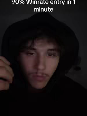 A dark, close-up shot of a young man wearing a black hoodie. The man has light skin, dark hair, and a mustache. The background is completely dark, and the lighting emphasizes the man's face and the hood of his jacket. Text overlayed reads "90% Winrate entry in 1 minute."
