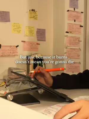 A desk is shown with sticky notes, a laptop, and an orange pen held in a hand. Text overlays the image.