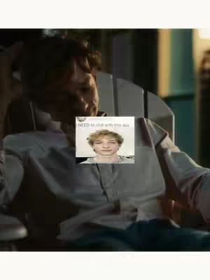 The image shows a man sitting in a chair with an overlayed video still image. The setting has soft, warm lighting, and the man's face is partly obscured, suggesting a casual atmosphere. A small framed image of what seems to be a younger similar looking man appears on the chest area.