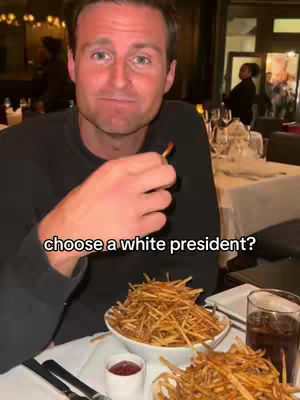 A man is seated at a restaurant table holding a french fry, with a bowl of fries in front of him and text overlayed. The composition includes a full bowl of fries and a glass of beverage.