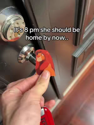 A hand holding a red key and a cutout of Simba from The Lion King in front of the door lock. Text overlayed saying, "It's 8 pm she should be home by now.."