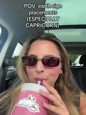 A woman in a car is shown in a medium close-up, wearing sunglasses and and drinking from a pink cup with a cartoon sticker. Text overlayed on the top of the image.