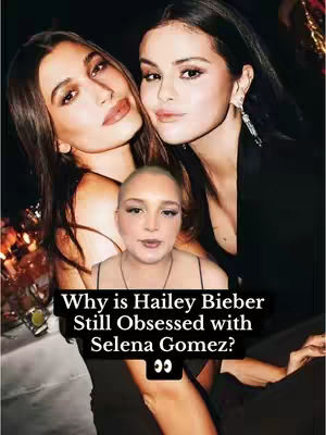The cover image is a composite showcasing three figures. In the background, two women, presumably Hailey Bieber and Selena Gomez, are pictured with a medium shot, with their faces and shoulders visible. They are elegantly dressed against a dark background. Overlaid on this is an additional portrait of a woman with a shaved head, positioned at the bottom, looking directly at the camera. Below her is a text overlay on a black box, in white sans-serif font that reads, "Why is Hailey Bieber Still Obsessed with Selena Gomez?" with a pair of eyes emoji beside it.