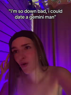A young woman with long brown hair and a black headband is looking towards the camera with a slightly surprised expression. The background is out of focus, with a purple hue, possibly from lighting.