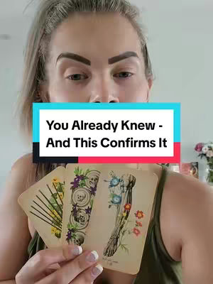 A woman with light hair and fair skin is holding up three tarot cards. She has a text overlay in the center. The cards themselves have illustrations of botanical designs with skulls and stems.