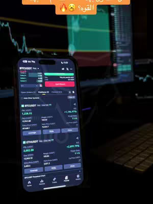 A smartphone displaying a trading app is the central focus, positioned in the foreground against a dimly lit background. The app interface shows real-time market data with price charts and financial metrics. The smartphone is angled slightly toward the viewer, with a blurred monitor and a keyboard visible in the background. Above the phone is an orange speech bubble with text. The color palette is dominated by dark tones, with the phone's screen displaying vibrant colors from the app's interface.