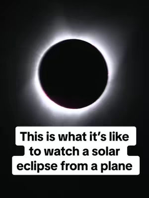 A photograph of a solar eclipse. The sun is completely obscured, appearing as a black circle surrounded by a bright halo. The image is set against a dark background. At the bottom, there's a white rectangular block with text within it.