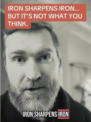 A black and white close-up of a middle-aged man with a full beard looking directly at the camera with a slightly surprised expression. Text overlays in rectangular boxes are present at the top and bottom of the image.