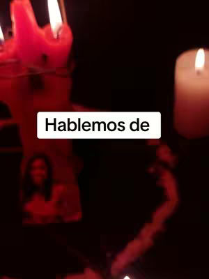 The cover image is a dark, interior scene. A large, ornate red candle is visible on the left side, with other bright candles further back. In the center, a white rectangle with the text "Hablemos de" (Let's talk about) floats over part of the image. To the right, a single lit candle fills the right side of the frame. The overall atmosphere is dim and the lighting is focused on the candles.