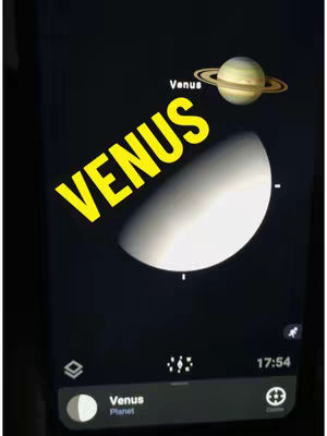 The cover image displays a screen showing a planetary exploration app. The word "VENUS" is prominently displayed in a large, yellow font diagonally across the image. Below the title is a white crescent shape of the planet Venus, and above is an illustration of Saturn. The app interface includes icons and the time 17:54.