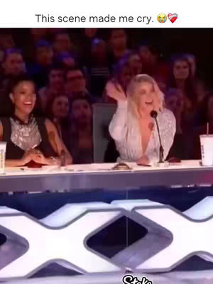 The cover image shows a scene from a talent show with two women on a panel. The woman on the left is smiling, and to the right, another woman is speaking into a microphone while laughing and gesturing with her hand. A crowd serves as the background.